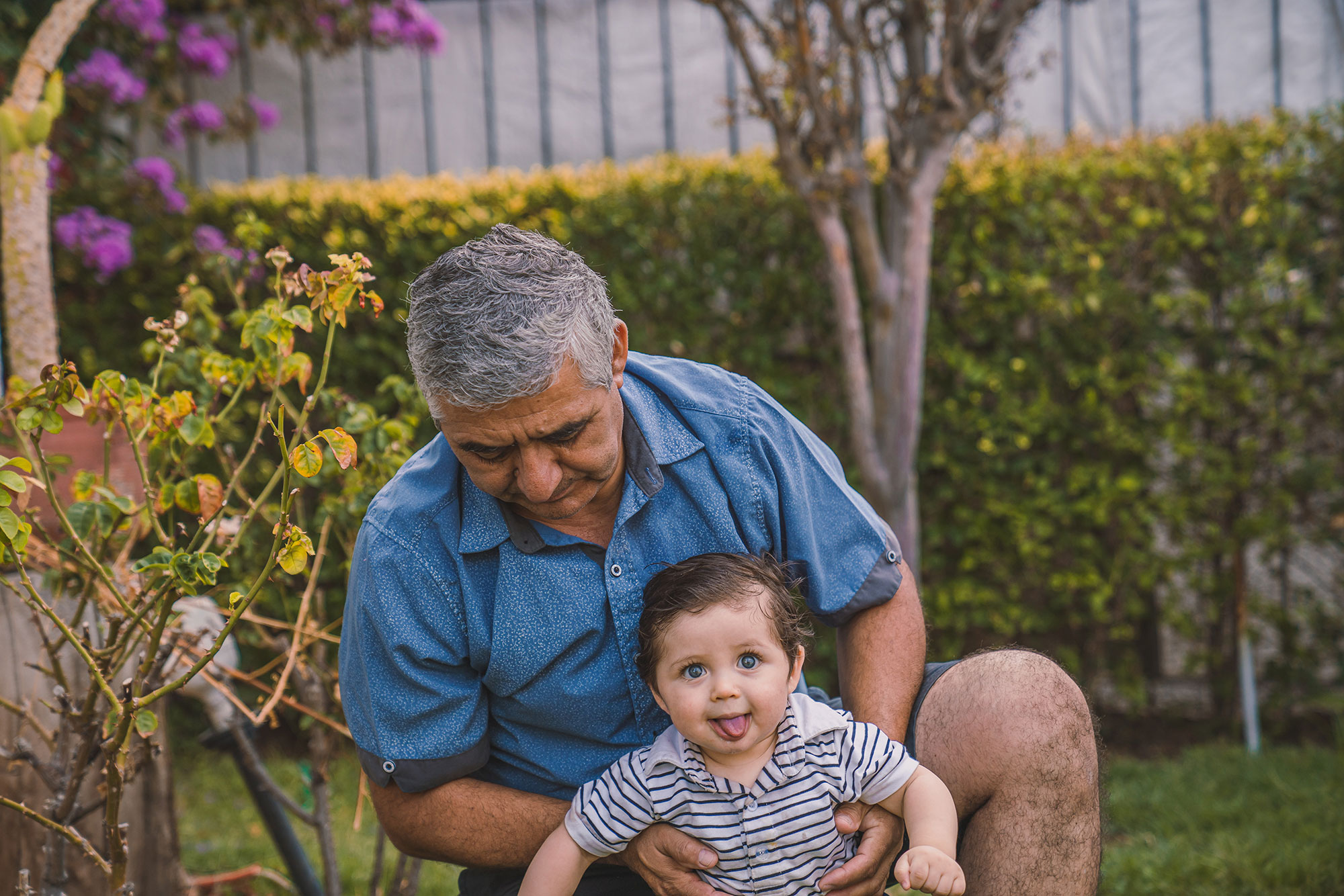 Grandfather playing with young grandson outside